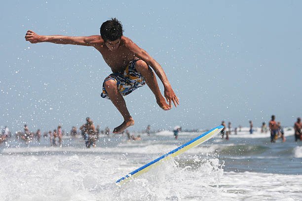 kid getting air on a bodyboard, skimboarding